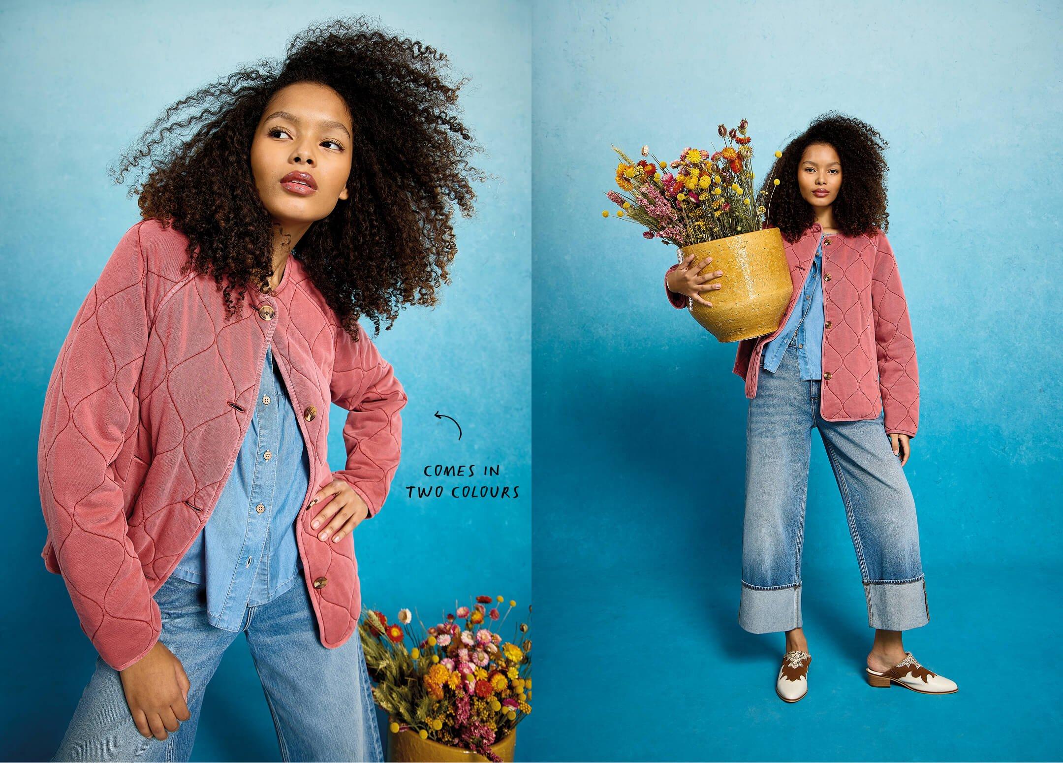 a woman in a pink jacket and jeans holding a flower pot