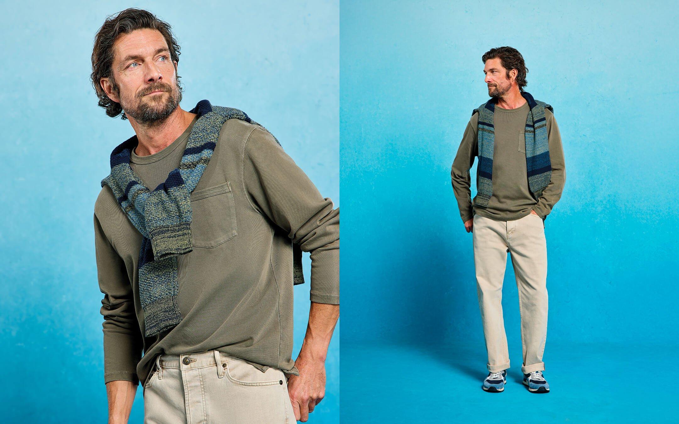 a man in a sweater and a scarf posing for a photo