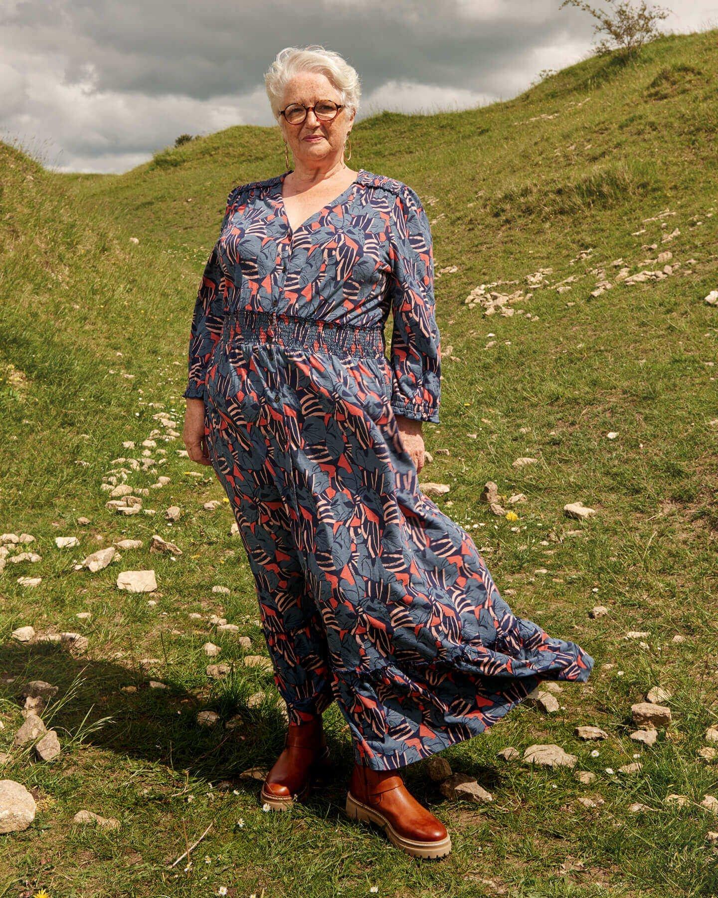 Customer Wendy in blue & pink printed long dress stood outside.