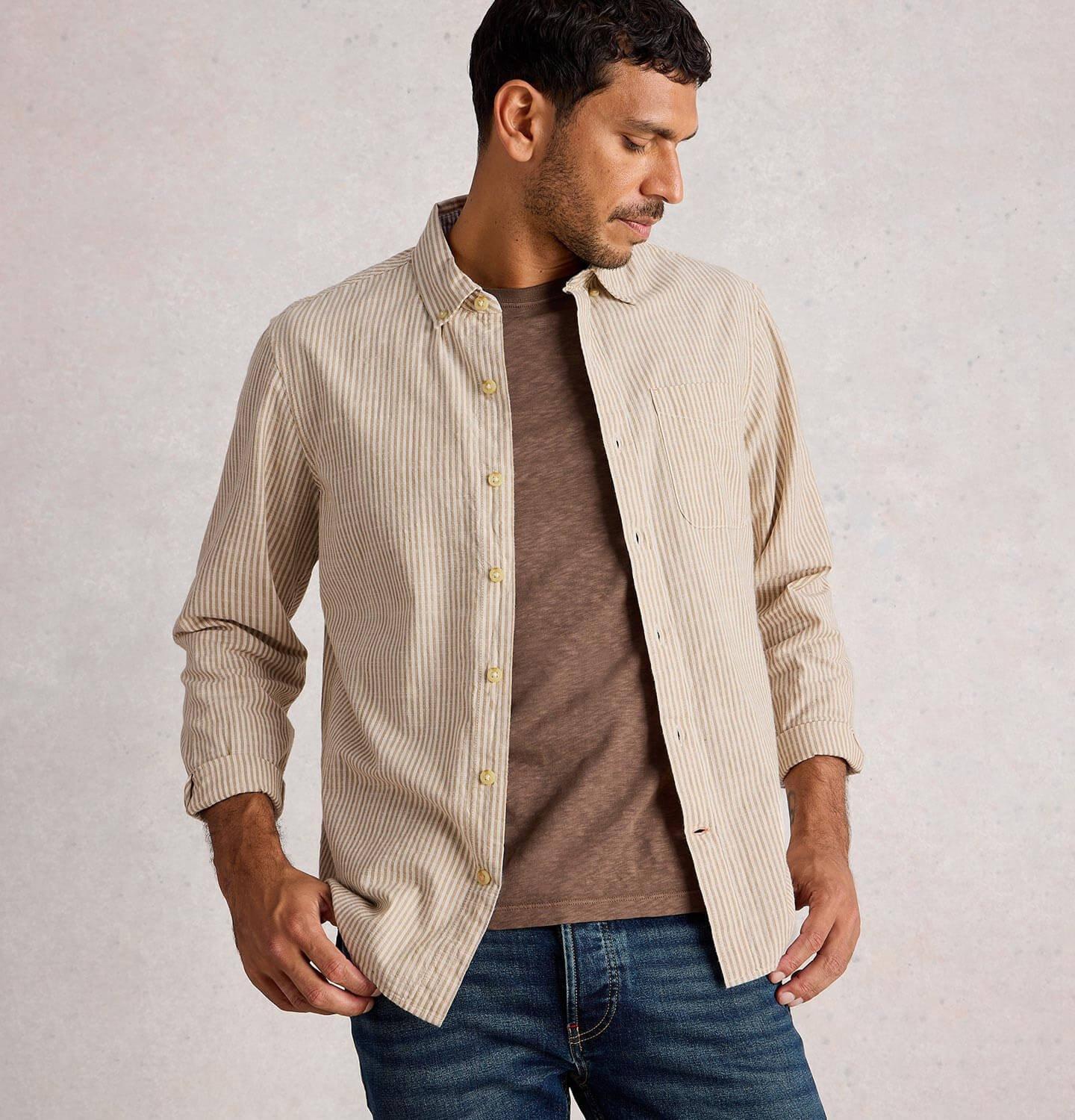 a man in a brown t-shirt and striped long sleeve shirt