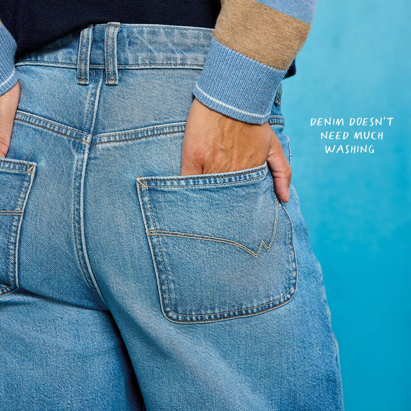 a woman in blue jeans with her back to the camera