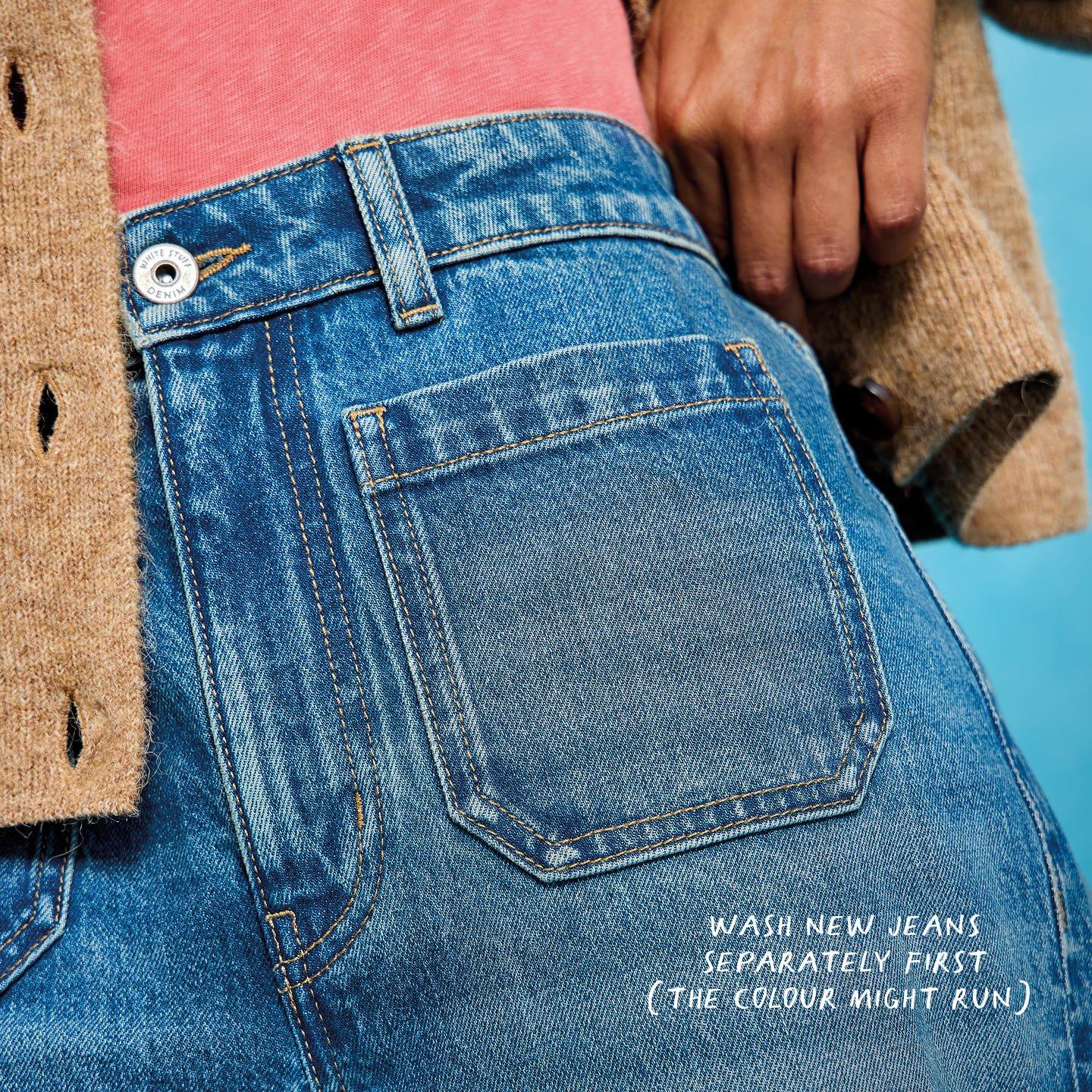a woman in blue jeans with her back to the camera