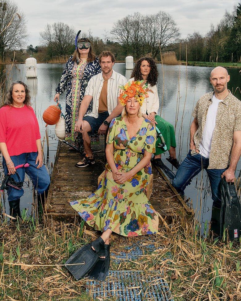 a group of people standing by a lake