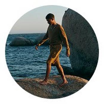 a man walking on a rock by the ocean