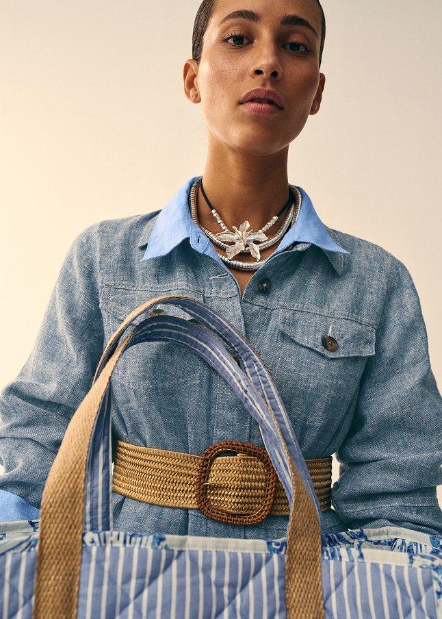 a woman holding a purse in one hand and a belt in the other