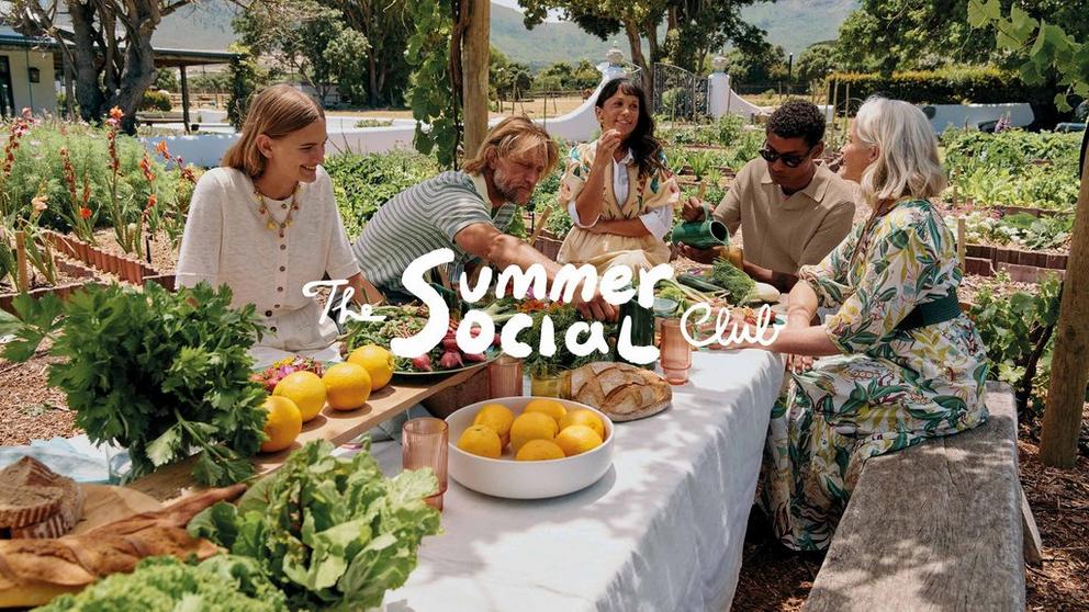 Photo of a group of people in a garden sharing food