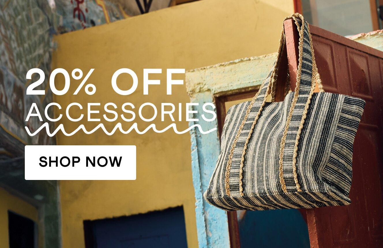 A jacquard tote hanging on a red door with the words '20% off accessories". Click here to shop accessories.