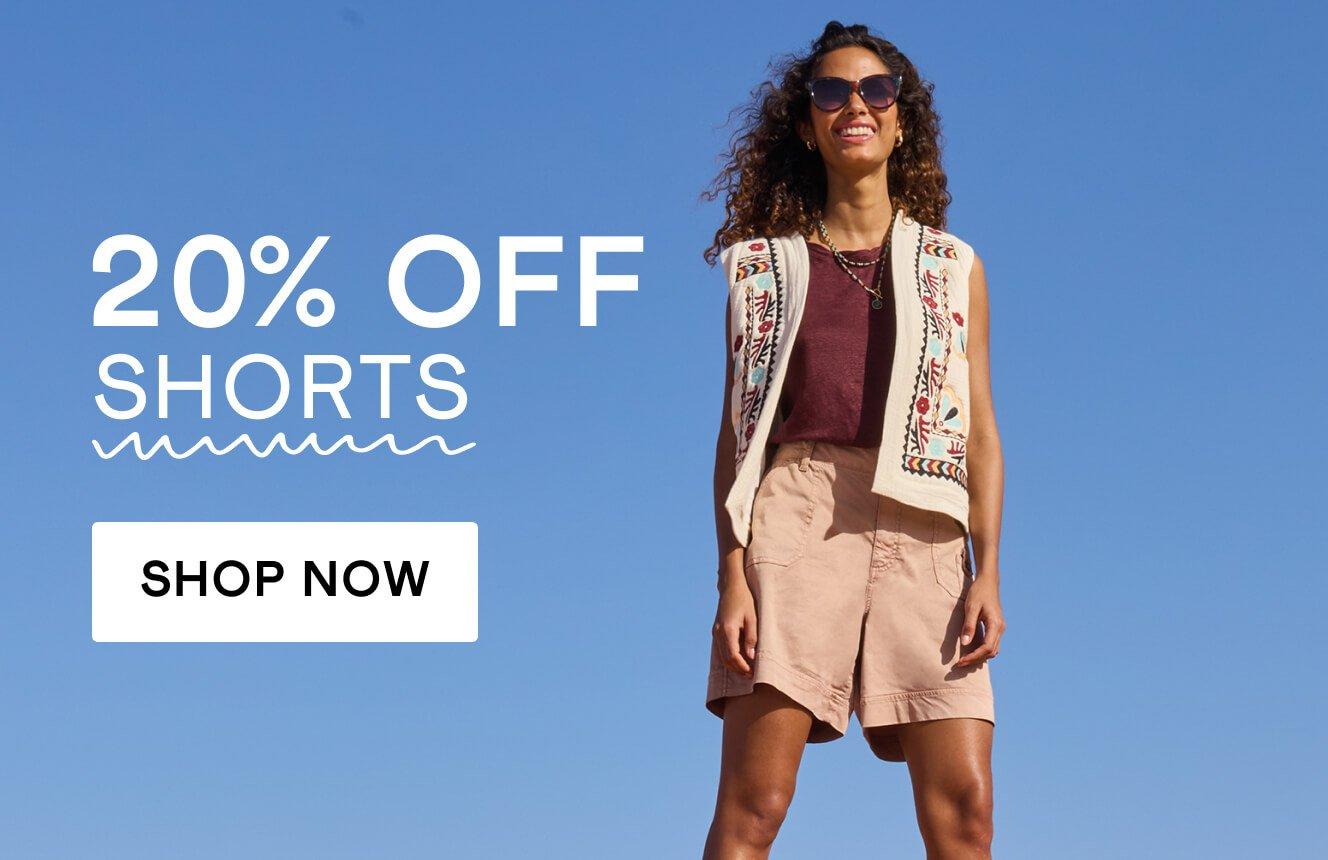 A woman wearing a purple top, an embroidered beige vest and beige shorts,  with the text "20% off shorts", Click here to shop shorts.