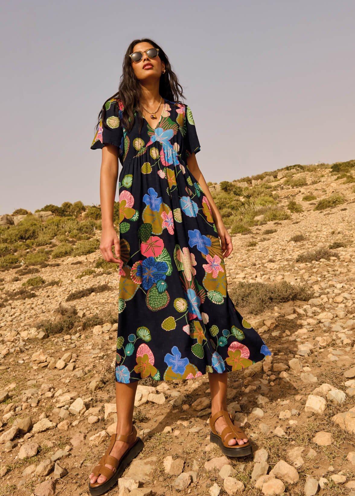 A woman wearing the Lucy Midi Dress and the Rose Leather Sandals