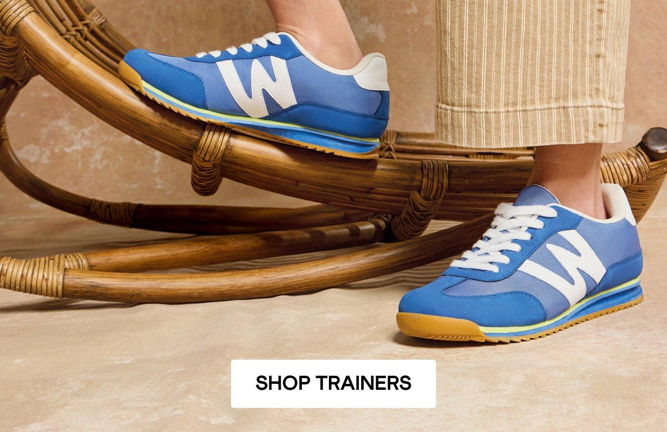 A close-up of a woman's feet, wearing the Cobalt Blue Lucy Trainers. Click here to shop trainers.