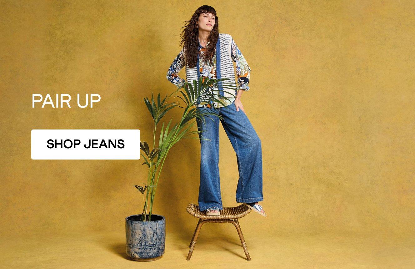 A woman wearing the Kyle Waistcoat, the Sophie Shirt and the Ayla Wide Leg Jeans. Text on the image is "pair up". Click here to shop jeans.