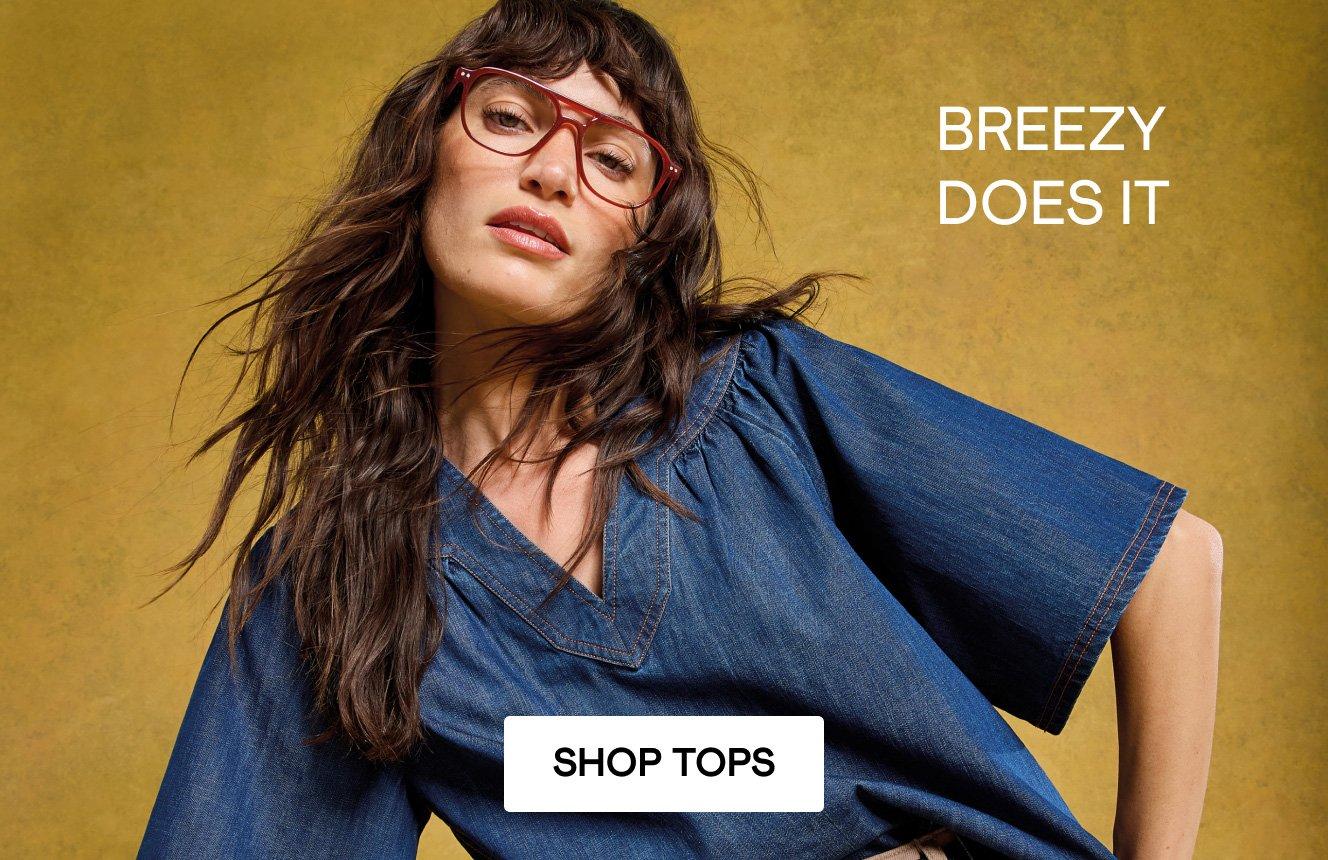 A woman wearing the Leo Denim Top, Text on the image is "breezy does it". Click here to shop tops.