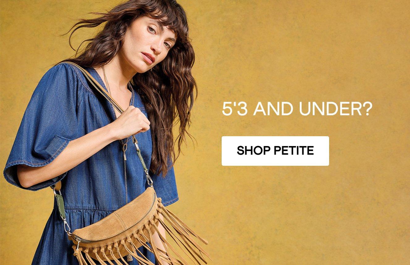 A woman wearing the Leo Denim Dress and Holding  the Mini Sebby Tassle Sling Bag. Text on the image is "5'3 and under?" Click here to shop petite clothing.