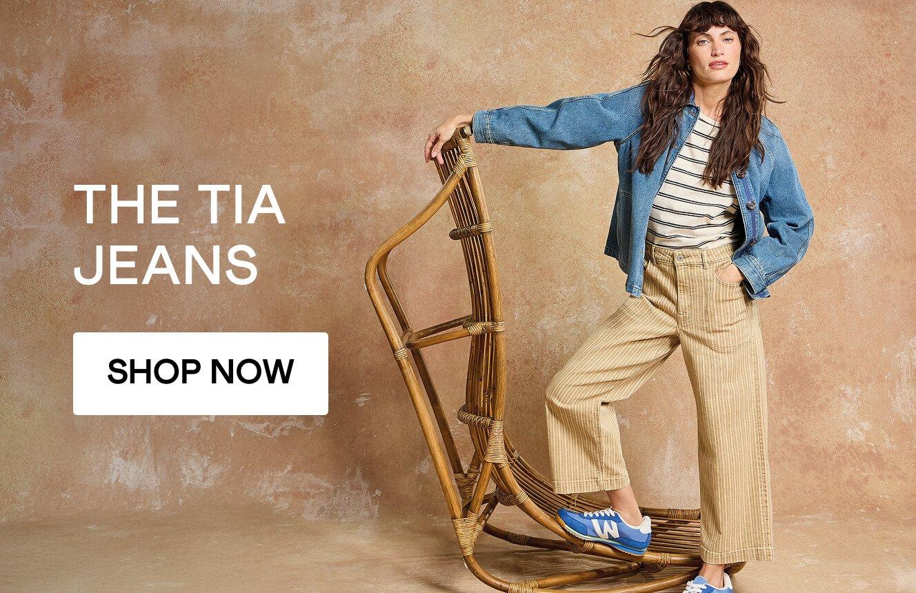 A woman wearing the yellow Tia Jeans and the blue Eden Jacket. Click here to shop all Tia Crop Wide Leg jeans.