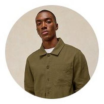 a man in a green shirt and black pants standing in a circle