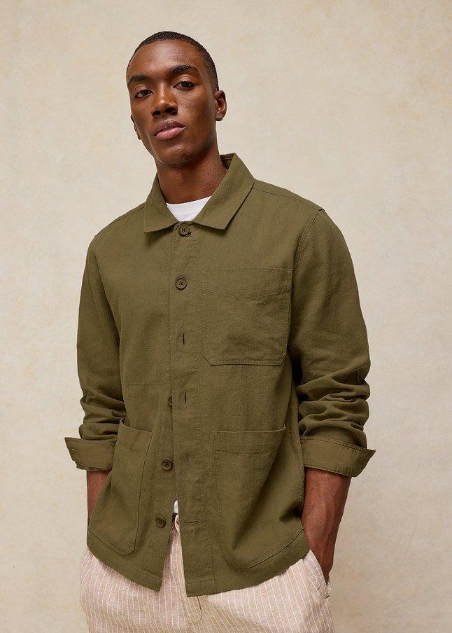 a man in a green jacket and pants standing up