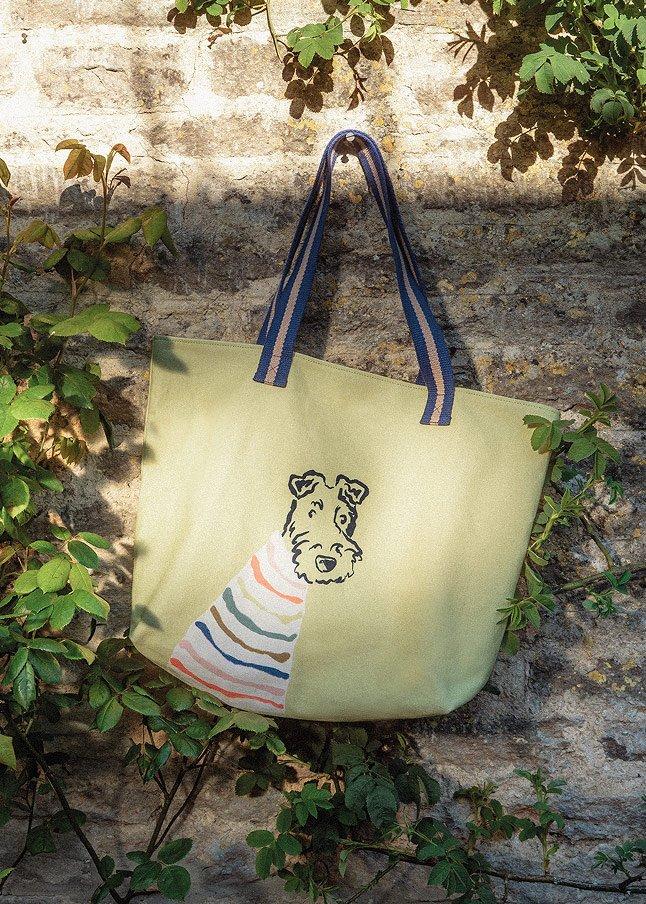a bag hanging from a tree branch with a dog on it