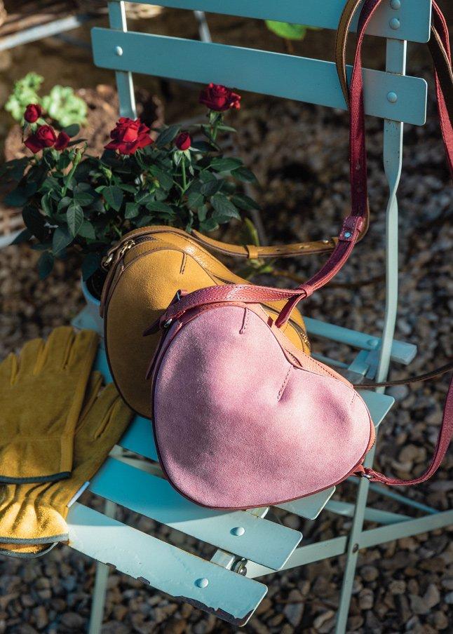 a pair of pink and brown purses sitting on a blue chair