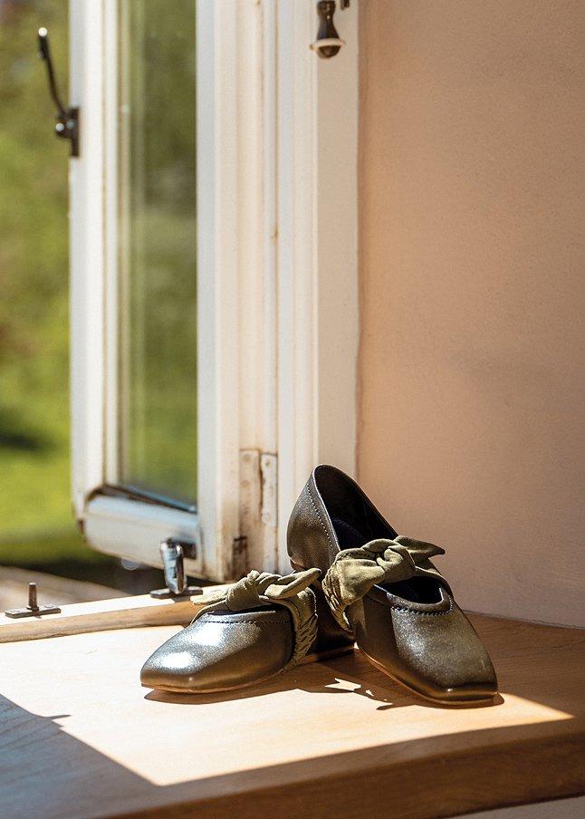 a pair of shoes sitting on a wooden table near a window