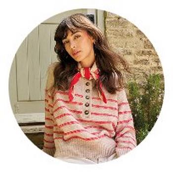 a woman in a striped sweater and red bow sitting on a bench