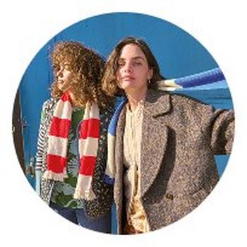 two women standing next to each other in a circle