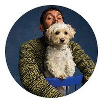 a man sitting on a chair with a dog in his lap