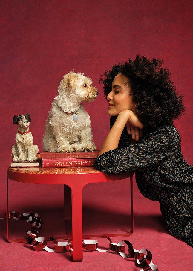 a woman laying on a red table with a dog on top of it