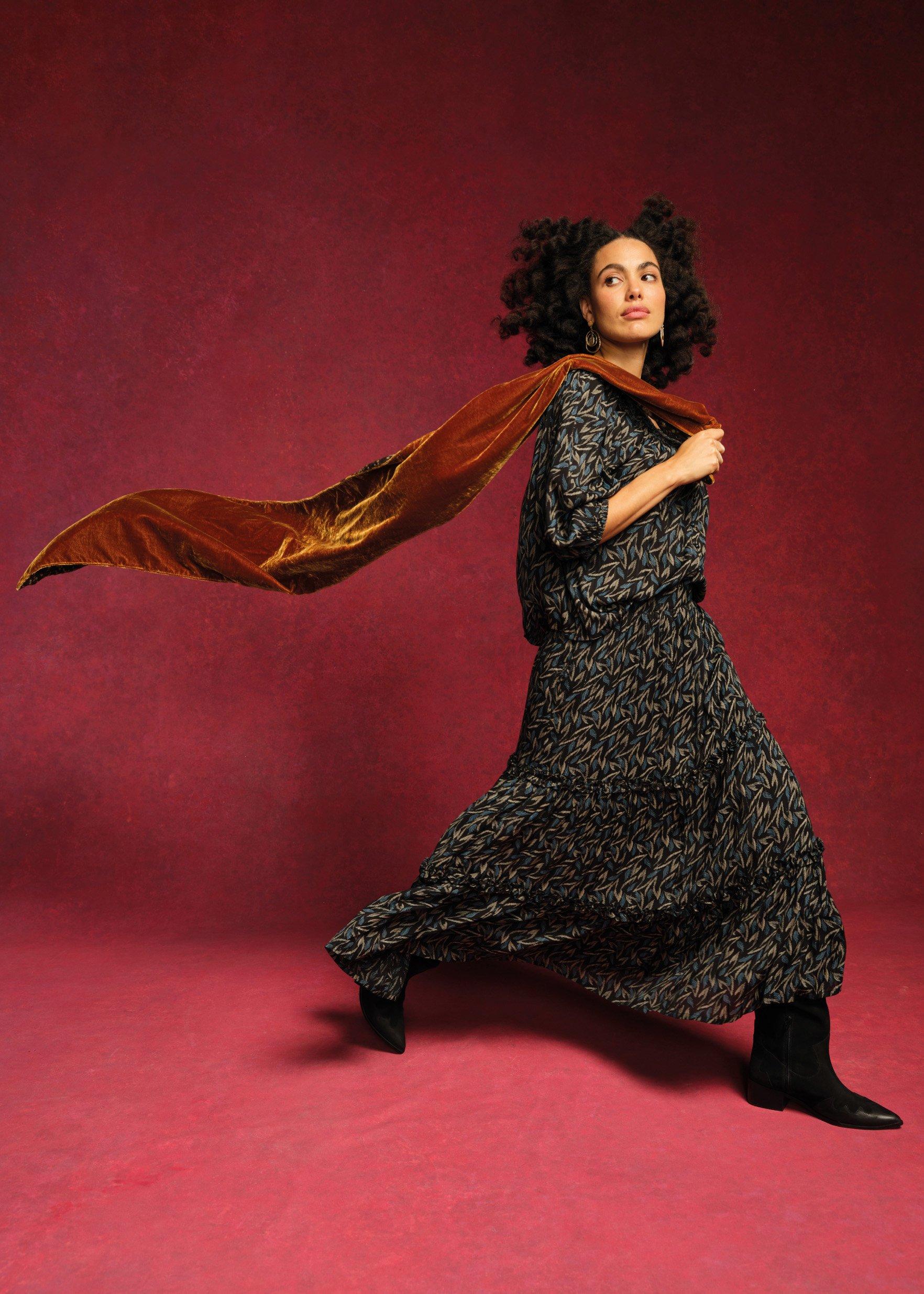 A woman wearing the Aster Top and the LEo Midi Denim Skirt