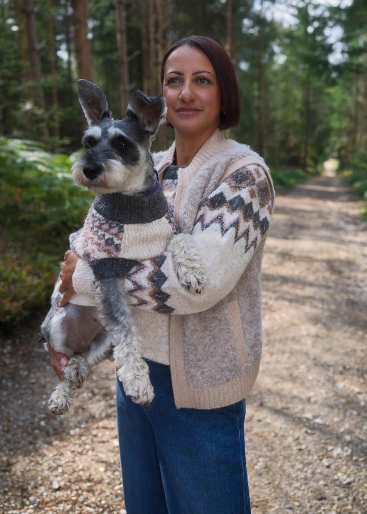 a woman holding a dog, both wearing matching Fairisle jumpers.