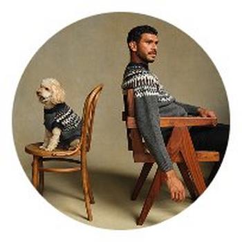 a man sitting on a chair with a dog sitting next to him