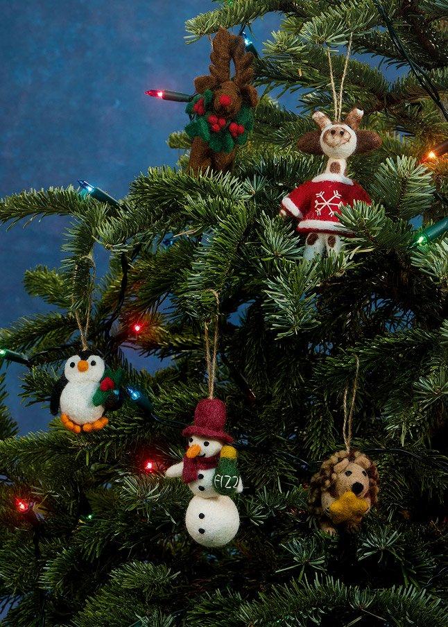a christmas tree with ornaments hanging from it and a blue sky