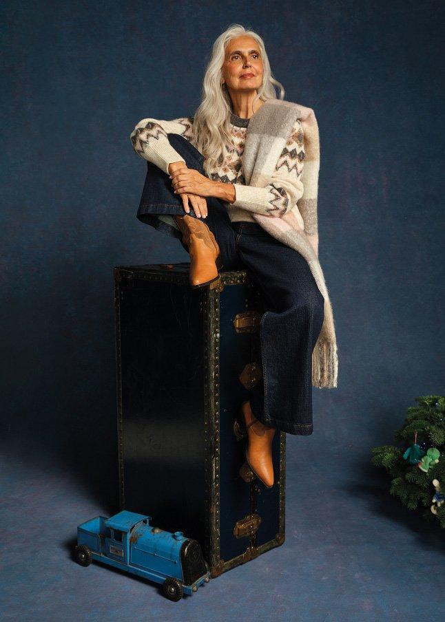 a woman sitting on a large suitcase