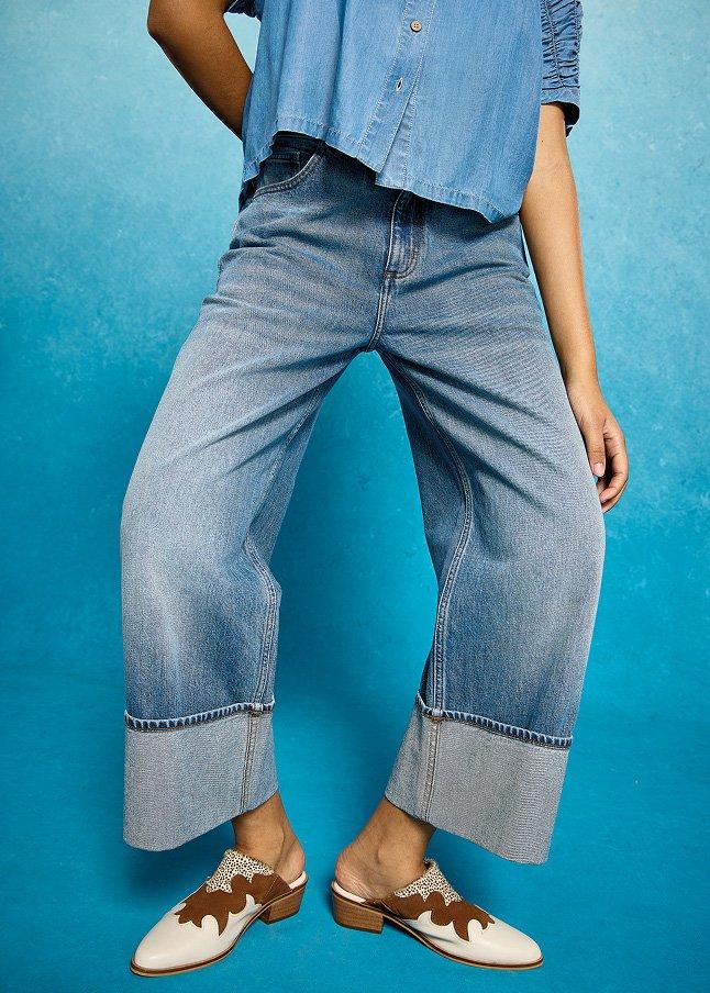 a woman in jeans and a shirt posing for a picture