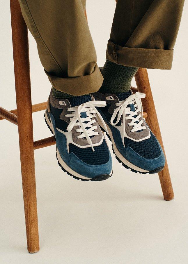 a person sitting on a wooden chair with their feet on the floor