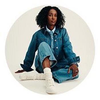 a woman sitting on a red table with a dog and a cat