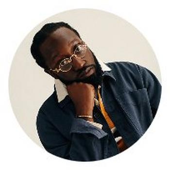 a man with glasses and a jacket posing for a picture