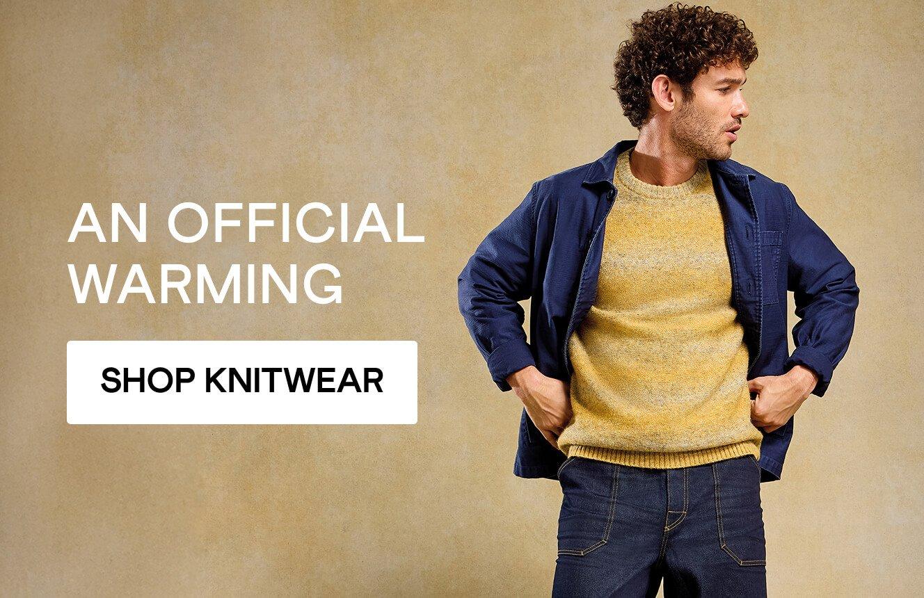 a man wearing a jumper with the text "an official warming", click here to shop knitwear