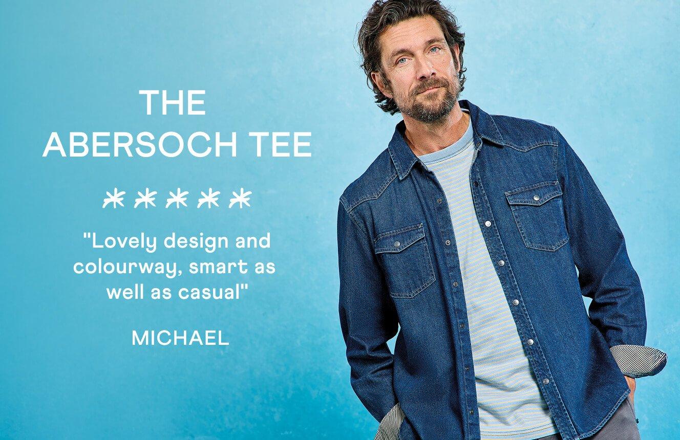 A man wearing the Abersoch Tee. Text on Image is a 5 star review written by Michael: ""Lovely design and colourway, smart as well as casual".