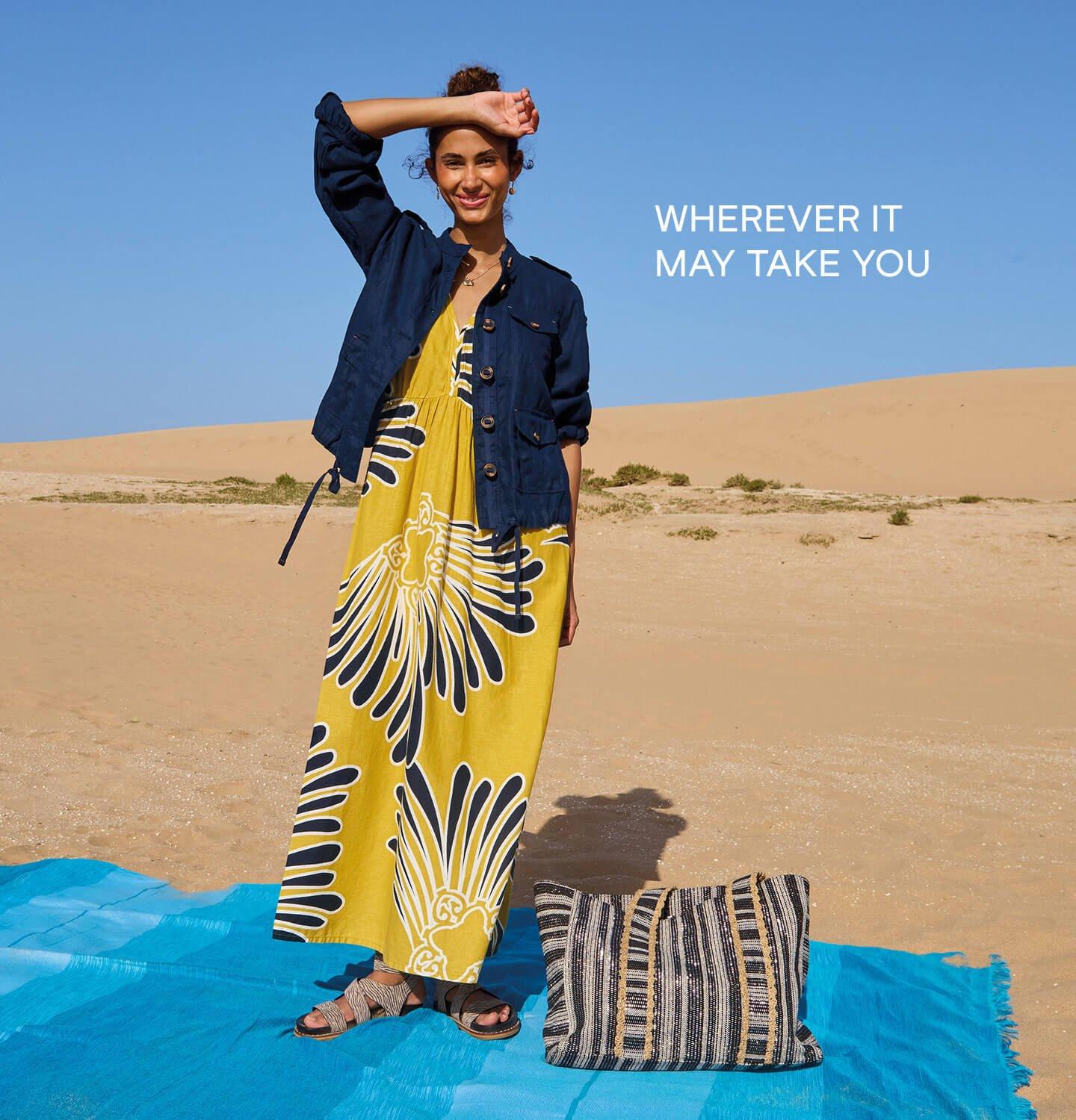 A female model wearing the yellow Lorna Maxi Linen Blend Dress with our dark navy Denim Utility Linen Jacket from White Stuff. The text on the image reads Where It May Take You