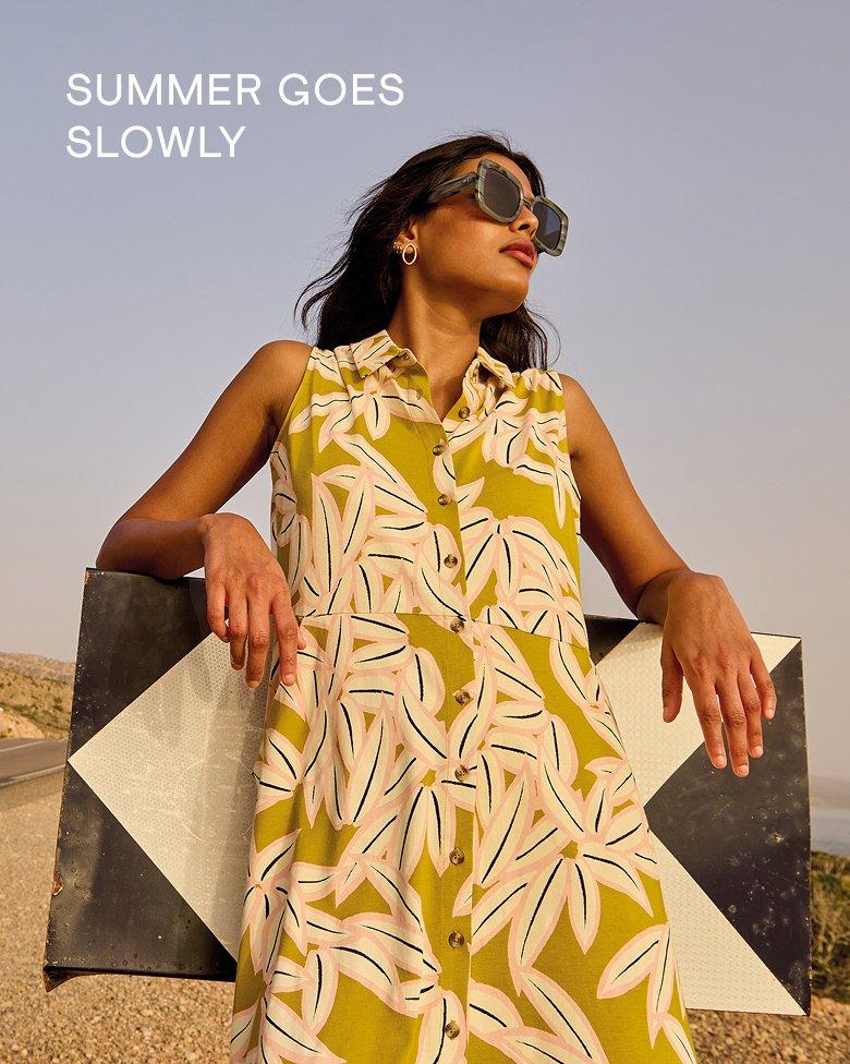 a woman in the Rua midi jersey dress standing next to a road sign
