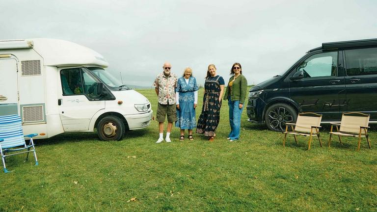 4 people in front of 2 caravans