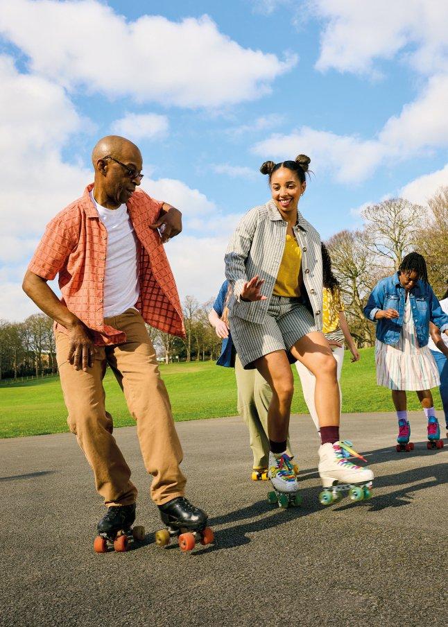 a group of people on roller skates in a park