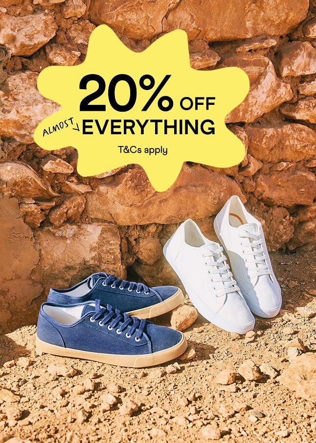 two pairs of shoes are sitting on a rock wall with the words 20 % off everything