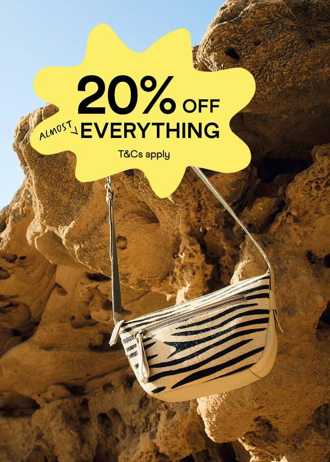 a purse hanging from a rock formation with a 20 % off sign