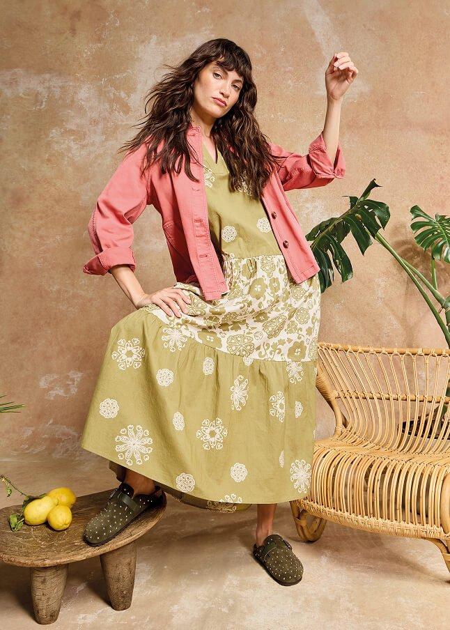 a woman in a dress posing for a picture in a room