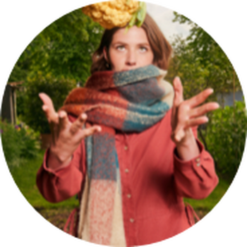 a woman in a red scarf and a yellow and green jacket