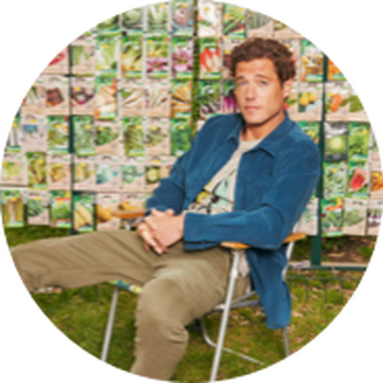 a man sitting in a chair with a bunch of pictures behind him